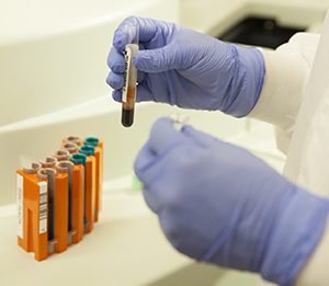 Lab tech with lab equipment and blood samples.