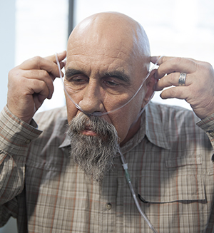 Man putting on a nasal cannula.