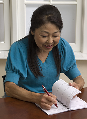 Woman writing in calendar.