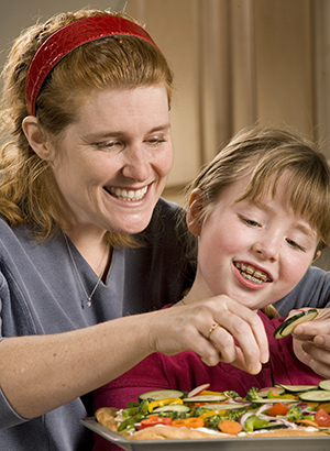 Mujer y niña preparando la comida.